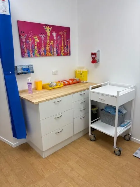 Treatment room with bench, supplies and a mobile trolley